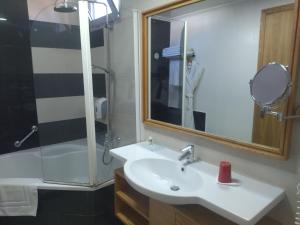 拉巴特Le Pietri Urban Hotel的一间带水槽、淋浴和镜子的浴室