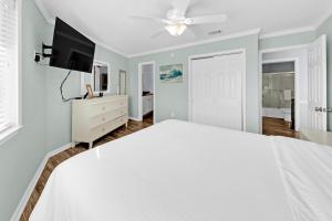 德斯坦Crystal Village II 19B - 2BD 2BA Condo near the Beach sleeps 6的卧室配有白色的床和平面电视。