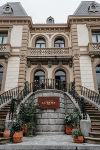 蒙达卡Hotel Luruna Palacio Larrinaga的前面有楼梯和盆栽的建筑