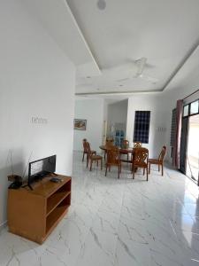 Kota BharuHomestay PCB Villa MamaKaya的客厅配有电视和桌椅