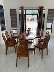 Kota BharuHomestay PCB Villa MamaKaya的一间带木桌和椅子的用餐室