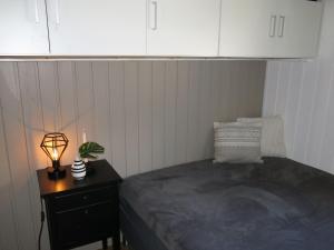 FossdalHoliday Home Utsikt - SOW148 by Interhome的一间卧室配有一张床和一张带台灯的桌子