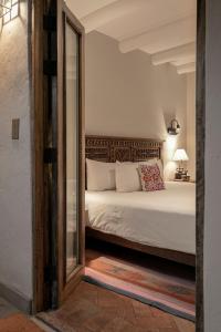 库斯科安提瓜卡索纳圣布拉斯酒店的一间卧室配有一张床和镜子