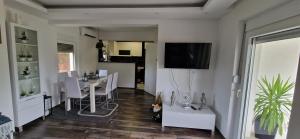 尼什Vila Elena的客厅配有餐桌和墙上的电视