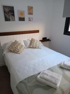 洛斯马蒂雷斯APARTAMENTOS Posada Del Mar的一张白色的床,上面有两条毛巾