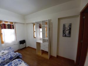 乌斯怀亚hostel comunidad Ushuaia的一间卧室配有一张床、梳妆台和镜子