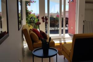 里斯本里斯本丁斯酒店的客厅配有沙发和带花瓶的桌子