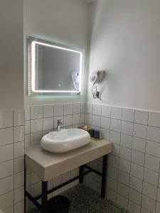 乌雷基H2O的一间带镜子和窗户的盥洗盆的浴室