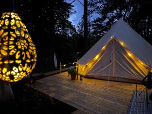 玛丽费莱德tent delhi a b&b in a luxury glamping style的夜间木甲板上带灯的帐篷