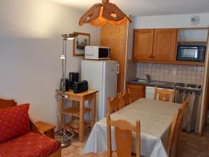 兰斯勒维拉德Appartement Lanslevillard, 2 pièces, 6 personnes - FR-1-508-107的厨房配有桌子和白色冰箱。