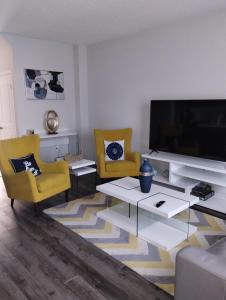 Beamsvilleluxurious 3-bedroom residential home in Lincoln的客厅配有大电视和黄色椅子