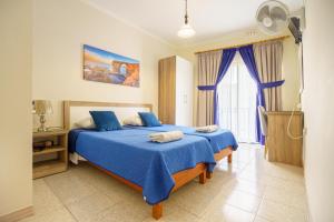 马萨尔福恩提灯旅馆的一间卧室设有两张带蓝色床单的床和窗户。