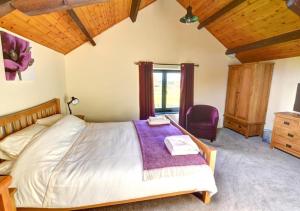 LlandinamY Beudy的一间卧室配有一张大床和紫色毯子