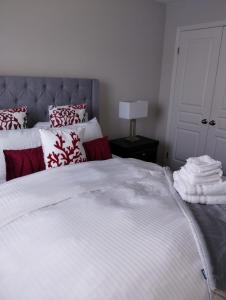 Beamsvilleluxurious 3-bedroom residential home in Lincoln的一间卧室配有一张带红色和白色枕头的大床