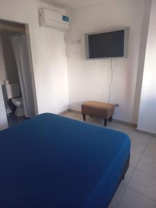 科尔多瓦Hotel CBA的一间卧室配有蓝色的床、椅子和电视