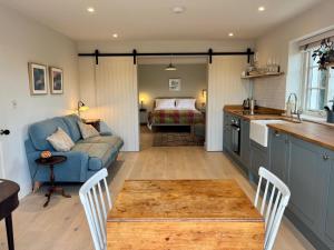 莱姆里吉斯Cobblers Lodge的厨房以及带沙发和桌子的客厅。