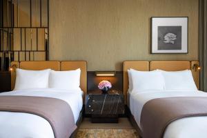 纽约The Ritz-Carlton New York, NoMad的配有白色枕头的酒店客房内的两张床
