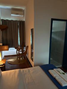 蒂拉登特斯Pousada Toro Real的一间卧室配有一张床、一张桌子和一面镜子