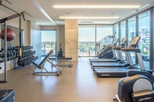 奥斯汀Highrise 1BR Luxe Suite near DT and Vibrant Rainey St的大楼内带有一排跑步机的健身房