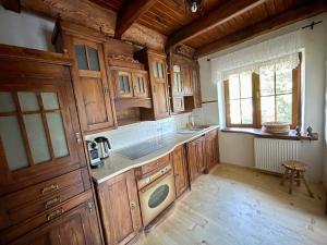 什切尔克Domek na Cuplu - opcjonalnie balia jacuzzi的厨房配有木制橱柜、水槽和窗户。