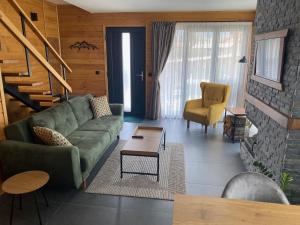 戈韦达尔齐HillVill的客厅配有绿色沙发和桌子