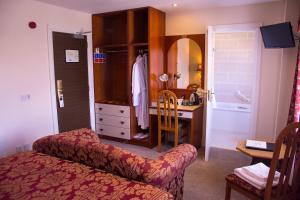 伦敦德里贝尔弗莱乡村酒店的客房设有带梳妆台和书桌的卧室