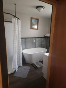 3 bed/2 bath Riverside cabin的浴室配有白色浴缸和淋浴。