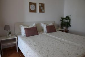 波尔托罗Apartments Fink的卧室配有白色的床和2个枕头