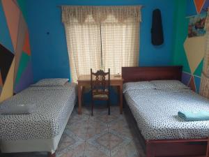 巴克里索莫雷诺港C.C. Habitaciones的一间卧室配有两张床、一张桌子和一张桌子