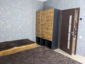 久姆里Sundukyan Apartments的一间卧室配有一张床和一个木制橱柜