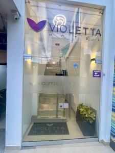 CeretéHOTEL VIOLETTA Cereté的商店的窗口,上面有标志