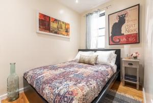 纽约4BR in Amsterdam Ave的卧室配有一张床,地板上设有花瓶