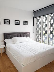 地拉那Tirana Central Apartments - Premium的窗户客房内的一张白色床