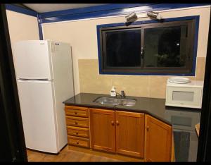 派桑杜ONE TRIP的厨房配有白色冰箱和水槽