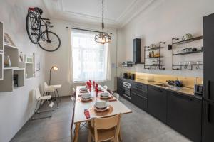 布鲁塞尔Superb 3 Bedroom & 3 Bathroom Duplex In Brussels City Centre的厨房配有桌子,墙上挂有自行车