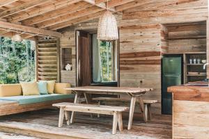 博卡斯德尔托罗Bocas Garden Lodges的小木屋配有桌子和长凳