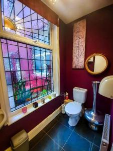 布莱克浦Hotel LUX (Rouge)的一间带卫生间和彩色玻璃窗的浴室
