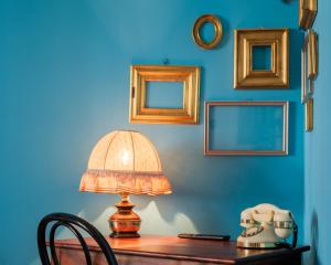 博洛尼亚Fabula Rooms 3 Suites with private bathroom的一张桌子,上面有一盏灯,墙上是蓝色的