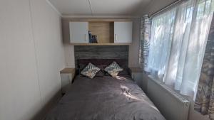 波特马多克Luxury caravan的一间小卧室,卧室内配有一张床铺