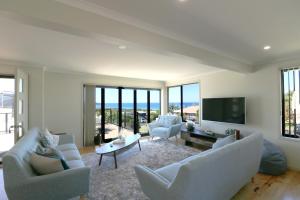 Tura BeachThe Views - 3 or 4 Bedroom的客厅配有沙发、椅子和电视