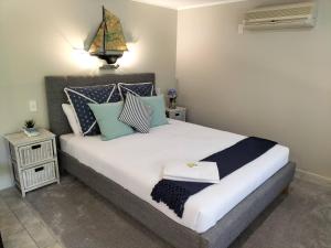 OpuaWildferns Lodge and Sailors Studio Opua的一间卧室配有一张带蓝色和白色枕头的床