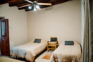 贝伦Huaco Casa de Campo的一间卧室配有两张床和吊扇