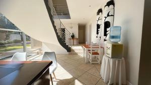 约翰内斯堡Sizanazo Guest House - in the Heart of Northcliff Hill的带楼梯的客房和带椅子的厨房
