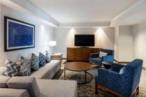 波特兰Embassy Suites by Hilton Portland Airport的客厅配有沙发、椅子和电视