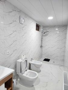 西格纳吉库斯卡旅馆的白色的浴室设有卫生间和水槽。