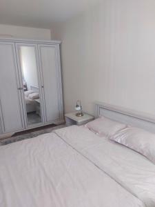 波德戈里察Oscar的卧室配有白色的床和镜子