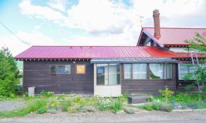 富良野古民家ここにわ はなれの宿的一间红色屋顶的小房子
