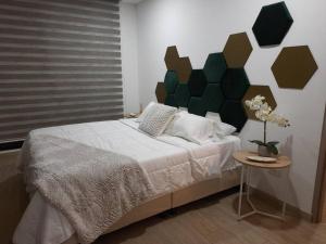 伊瓦格SuiteGreen, exclusivo apartaestudio !!的一间卧室配有一张大床和一张边桌