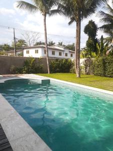 帕拉蒂Casarão Caborê的棕榈树屋前的游泳池