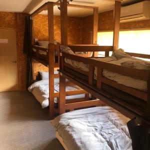 彦根市GUEST HOUSE NAGORIYA的房屋内带三张双层床的房间
